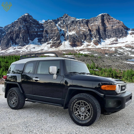 Black FJ Cruiser parked on a gravel surface withFJ Cover on the bumper