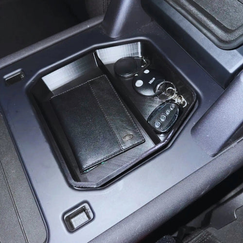 Defender armrest tray top-down view with stored items — Rigid Custom Works