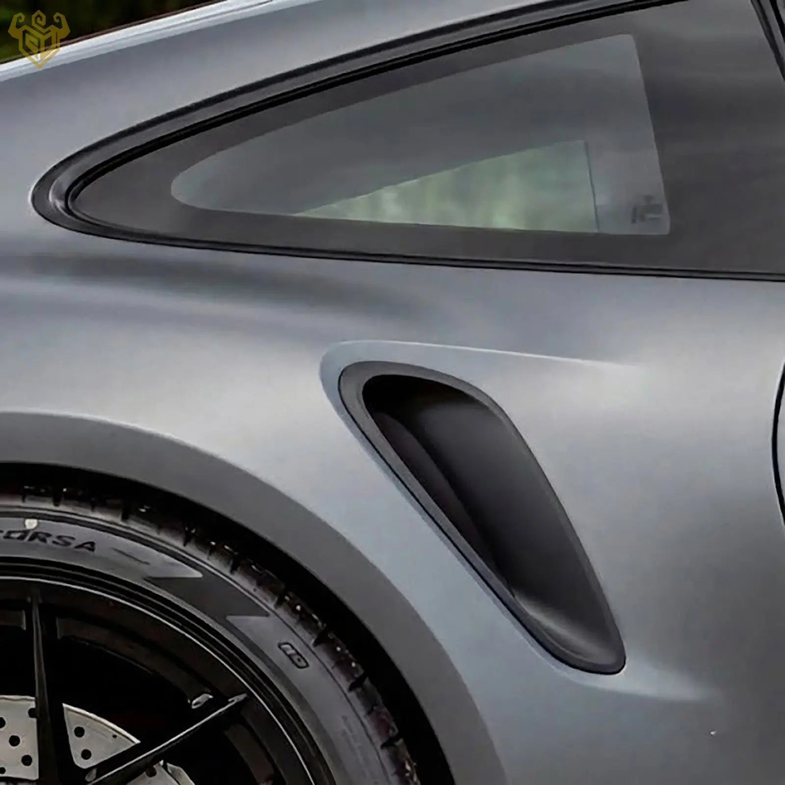 Side view of a Porsche 992 GT3 RS showing the aerodynamic rear wheel arch vent in matte black.