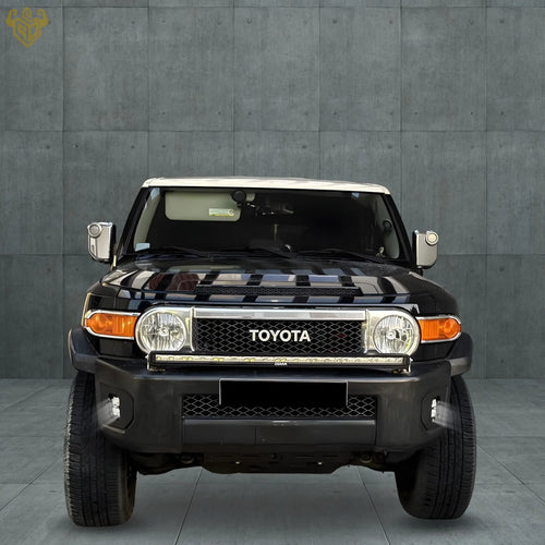 Front view of a black Toyota FJ Cruiser showing installed RIGID CUSTOM WORKS bumper light brackets with integrated Osram lights, enhancing the vehicle's front end.